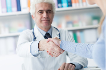 Naklejka na ściany i meble Doctor and patient shaking hands