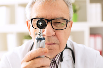Otolaryngologist looking through otoscope