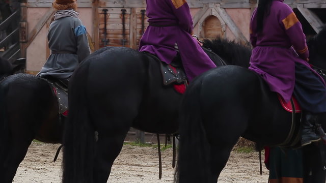 Actors dressed in medieval costumes playing roles of envoys on horseback