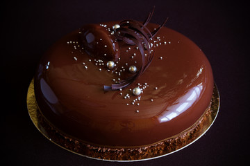Modern cake covered with chocolate glyassazhem.