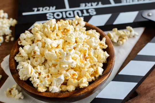 Movie clapper with popcorn on wooden background