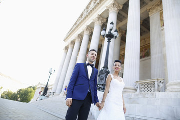 Beautiful bridal couple embracing near columns