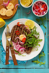 Roasted beef steak with onions and herbs.
