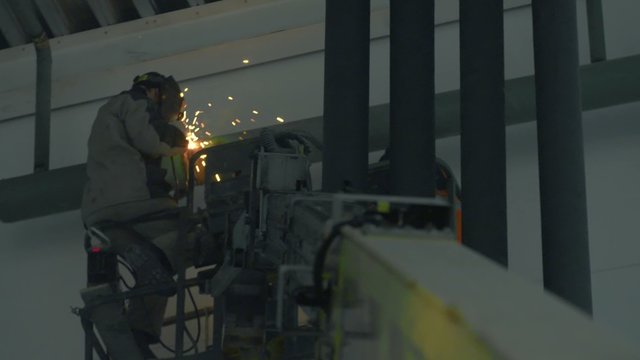 welder on crane in an industrial warehouse