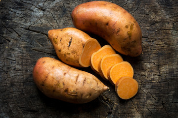 Raw sweet potatoes on wooden background  - 103731301