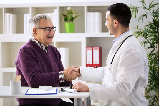 Doctor congratulating senior patient on recovery