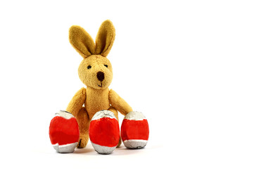 Obraz premium Easter bunny behind three eggs in a white background