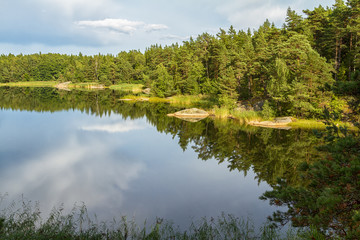 Calm forest lake with reflections in summer.