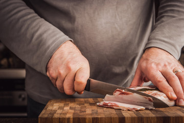 Man cutting lard in the kitchen