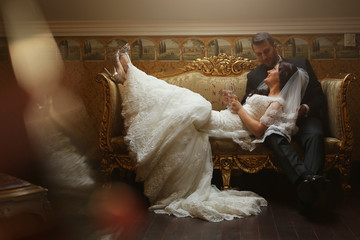 Bride and groom embracing on vintage sofa