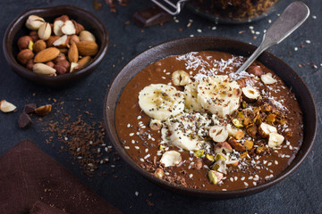 chocolate and banana smoothie  topped with nuts and seeds