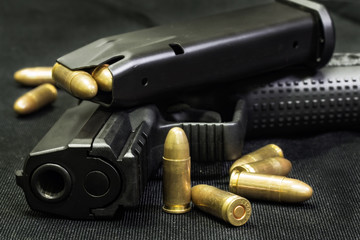 handgun with ammunition on a black surface © sanmartial