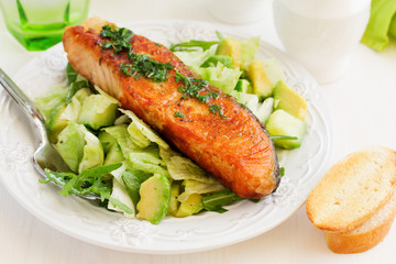 Fresh grilled salmon with a salad of avocado.