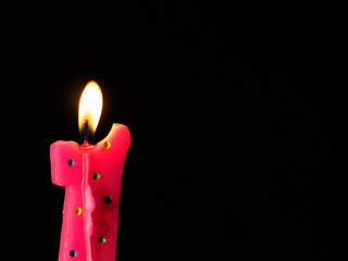 Pink candle against black background