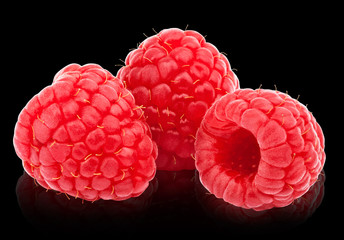 Three ripe raspberries isolated on black background with clipping path and reflections