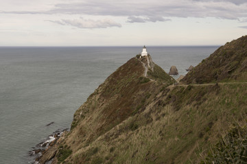 Fototapeta na wymiar Faro a lo alto de un acantilado en la costa de la Isla Sur de Nueva Zelanda