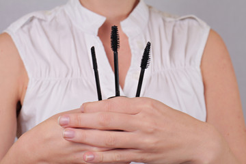 Mascara Wand Shapes. Woman holding different shapes of mascara wand close up