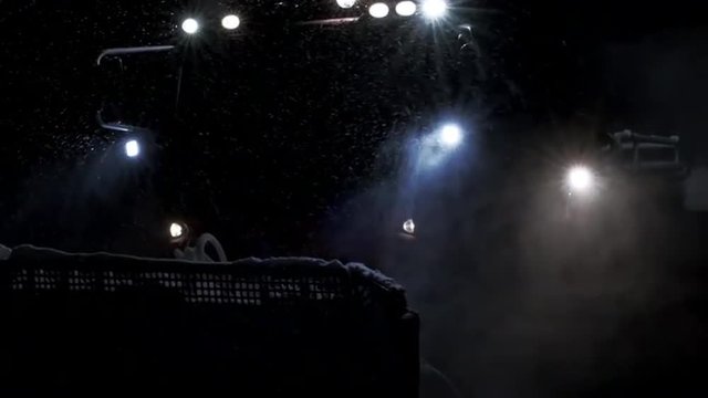 Amazing lights of snow groomer working at night.