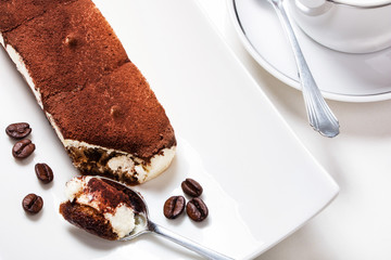 Tiramisu mit Kaffeebohnen, Löffel und Geschirr