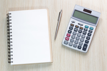 Top view of notebook, calculator and pen