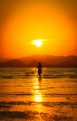Silhouette of girl on the beach at sunset.
