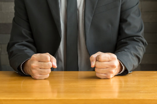 Businessman With Clenched Fist On The Desk At Office