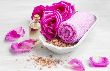 Obraz na płótnie Canvas Spa setting with roses ,bath salt and oil, cotton towel
