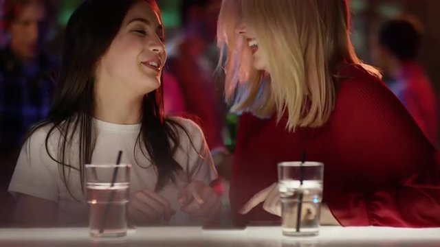 2 fr&ouml;hliche M&auml;dchen mit Handy an der Bar 
