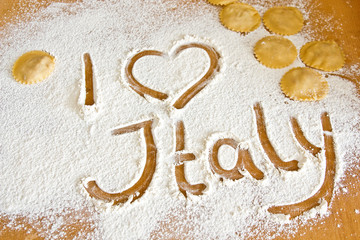 Lettering i love Italy on flour with ravioli