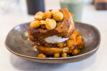 Closeup of macadamia sticky bun with ice cream, selective focus