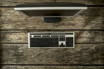 Fototapeta na wymiar Office computer keyboard and monitor on a wooden rustic desk