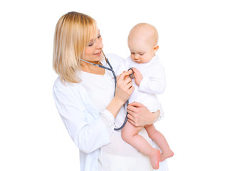 Woman doctor listens to heart of a child on white background