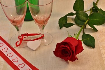 red rose with glasses on the table