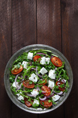 Salad with arugula, tomato, cheese and red onion