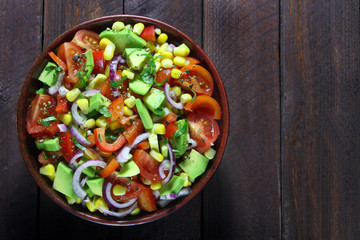 Salad with avocado, tomato, paprika, red onion and corn