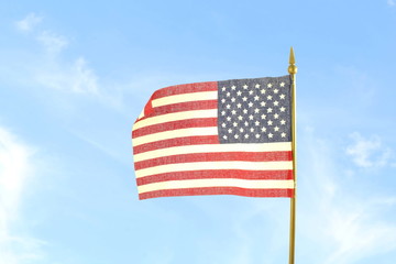 The us or American flag waving in blue sky background