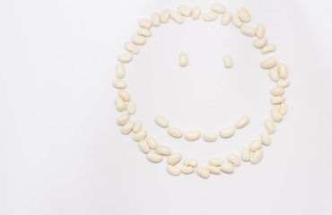 smiling emoticon with white beans isolated white background