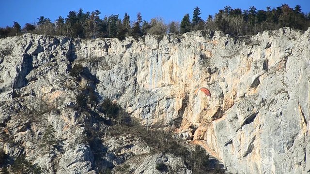 zwei paragleiter schweben bei hoher felswand
