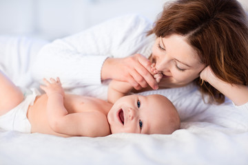 Obraz na płótnie Canvas Mother and baby on a white bed