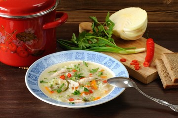 Cabbage soup with chicken served with rye bread, chilli, fresh g