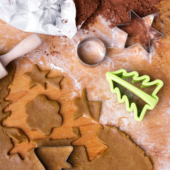 Cookies forms and gingerbread dough on wooden pastry board