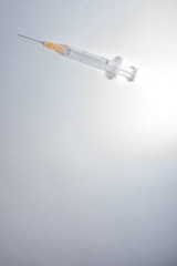 syringe on a light background vertically - obrazy, fototapety, plakaty