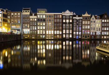 Obraz premium Buildings along the Damrak at Night in Amsterdam