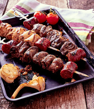 Grilled Meat Skewers and Vegetables on Hot Pan