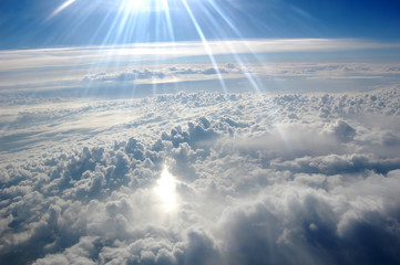 Fototapeta na wymiar Clouds, sun, sky as seen through window of an aircraft