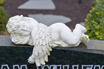 liegender Engel auf einem Grabstein