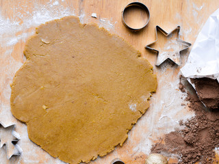 Cookies forms and gingerbread dough on wooden pastry board