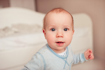 Cute baby boy in pajamas closeup. Looking at camera. Posing in room. Childhood.