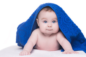 baby with big blue eyes looking at camera under blue towel/blank © IrBreeze