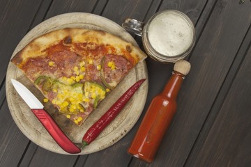 Homemade pizza. Portions of pizza on a dark wooden table. Food preparation.
